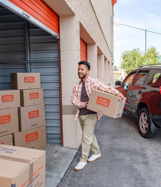 young man moving boxes into storage before moving abroad