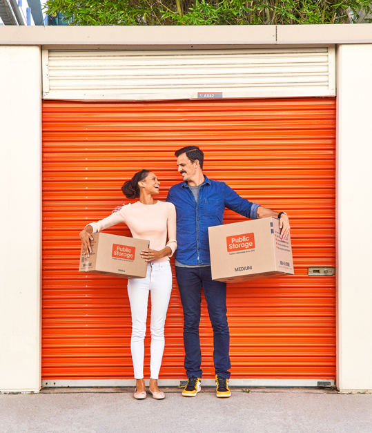 couple looking at each other in front of public storage